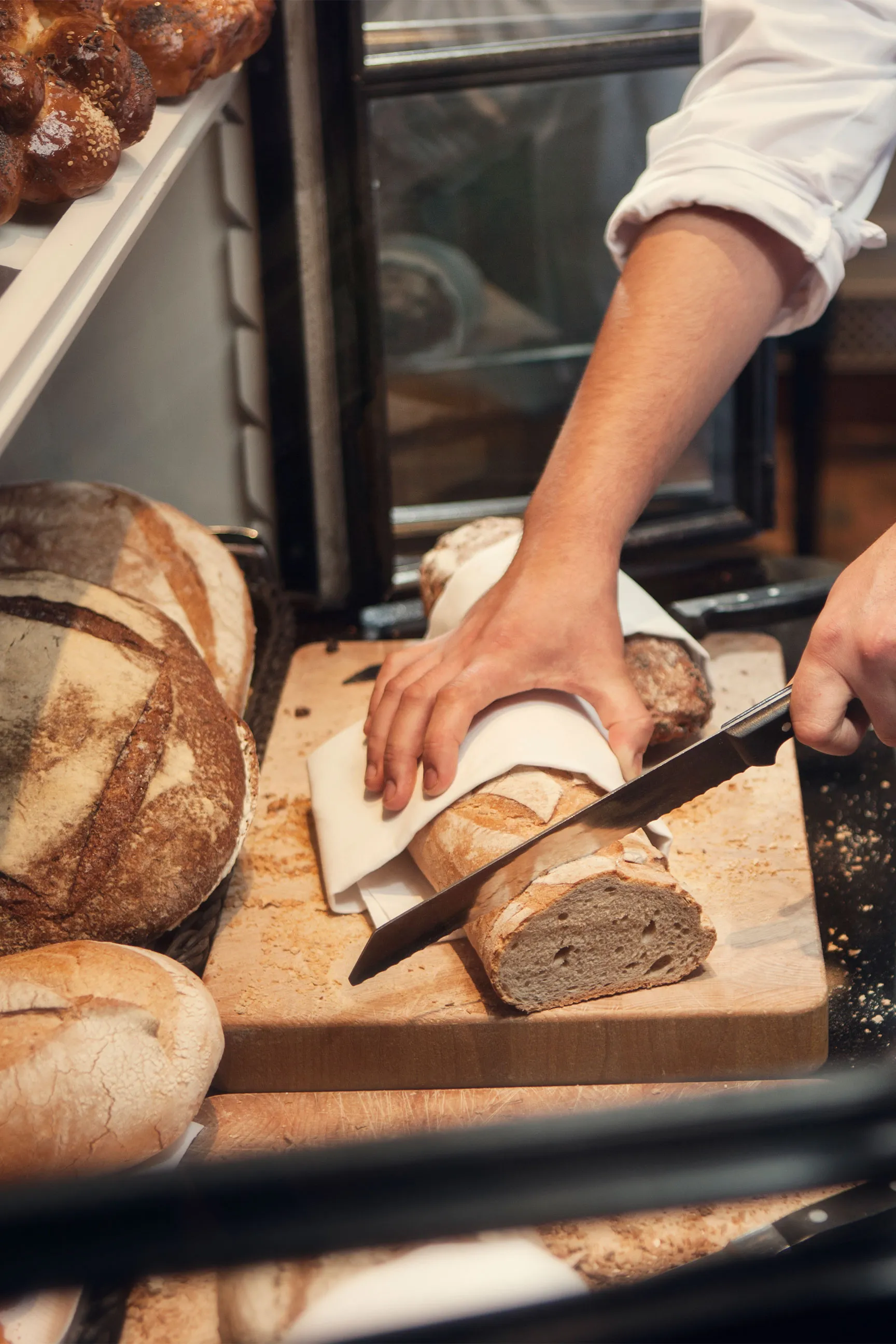 De chef die een vers brood afsnijdt